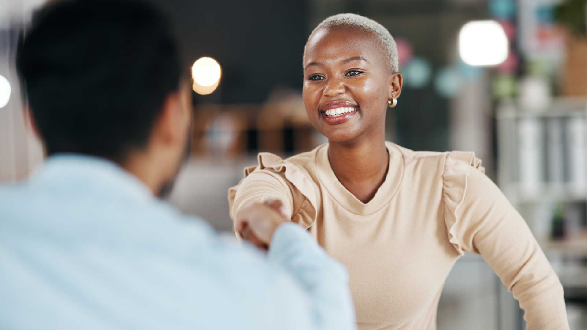 Woman shaking hands with male coworker.