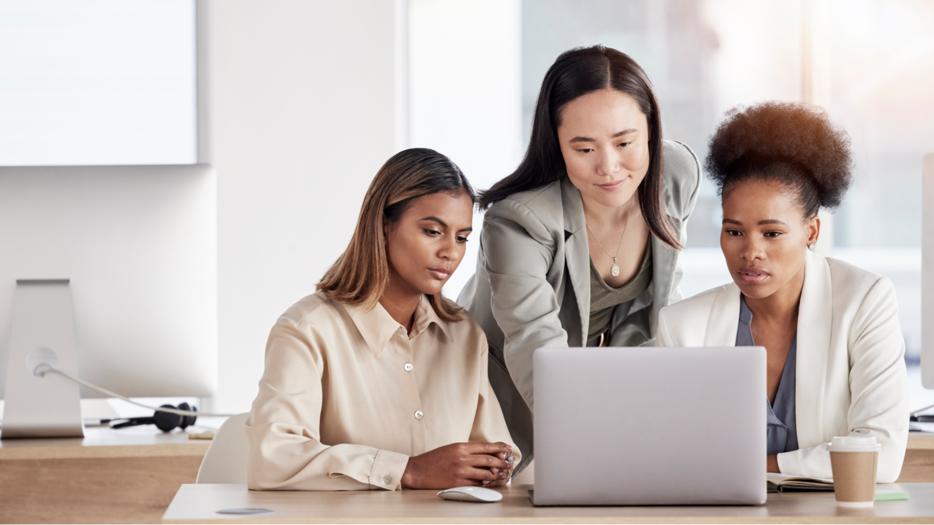 A group of female coworkers looking at project.
