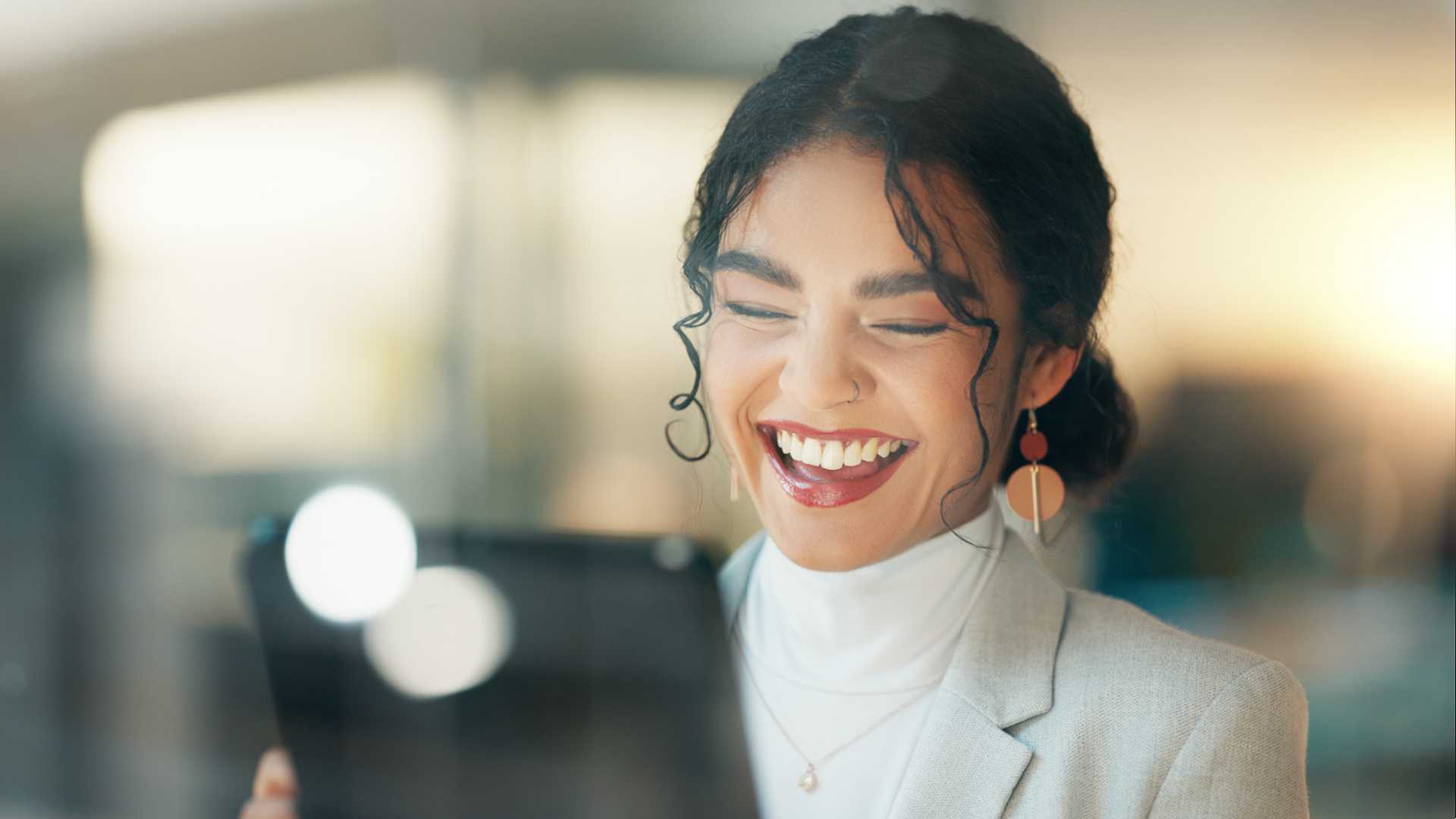 Woman looking at her iPad and smiling at something.