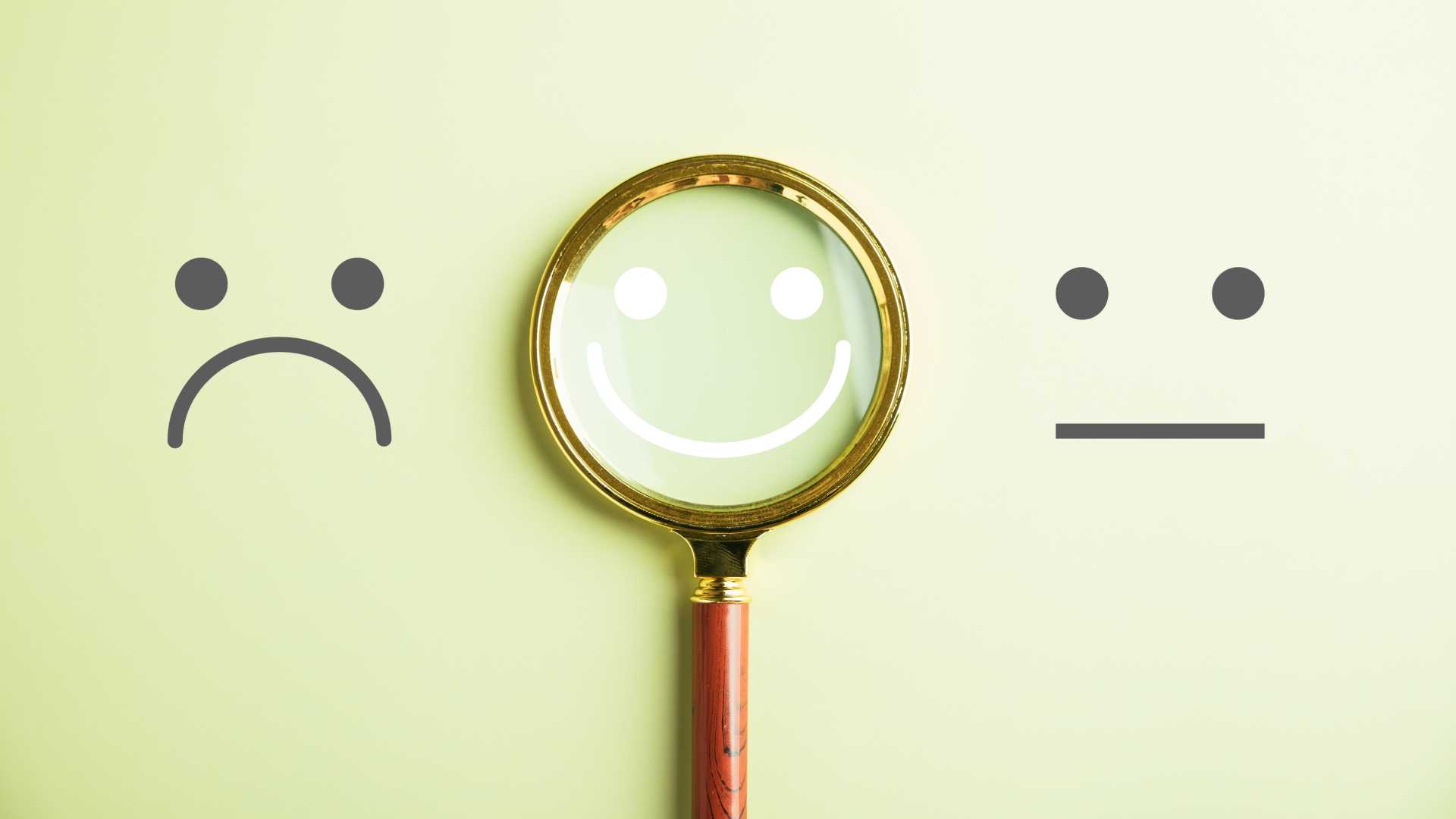 Sad face and Happy face under a magnetifying glass.