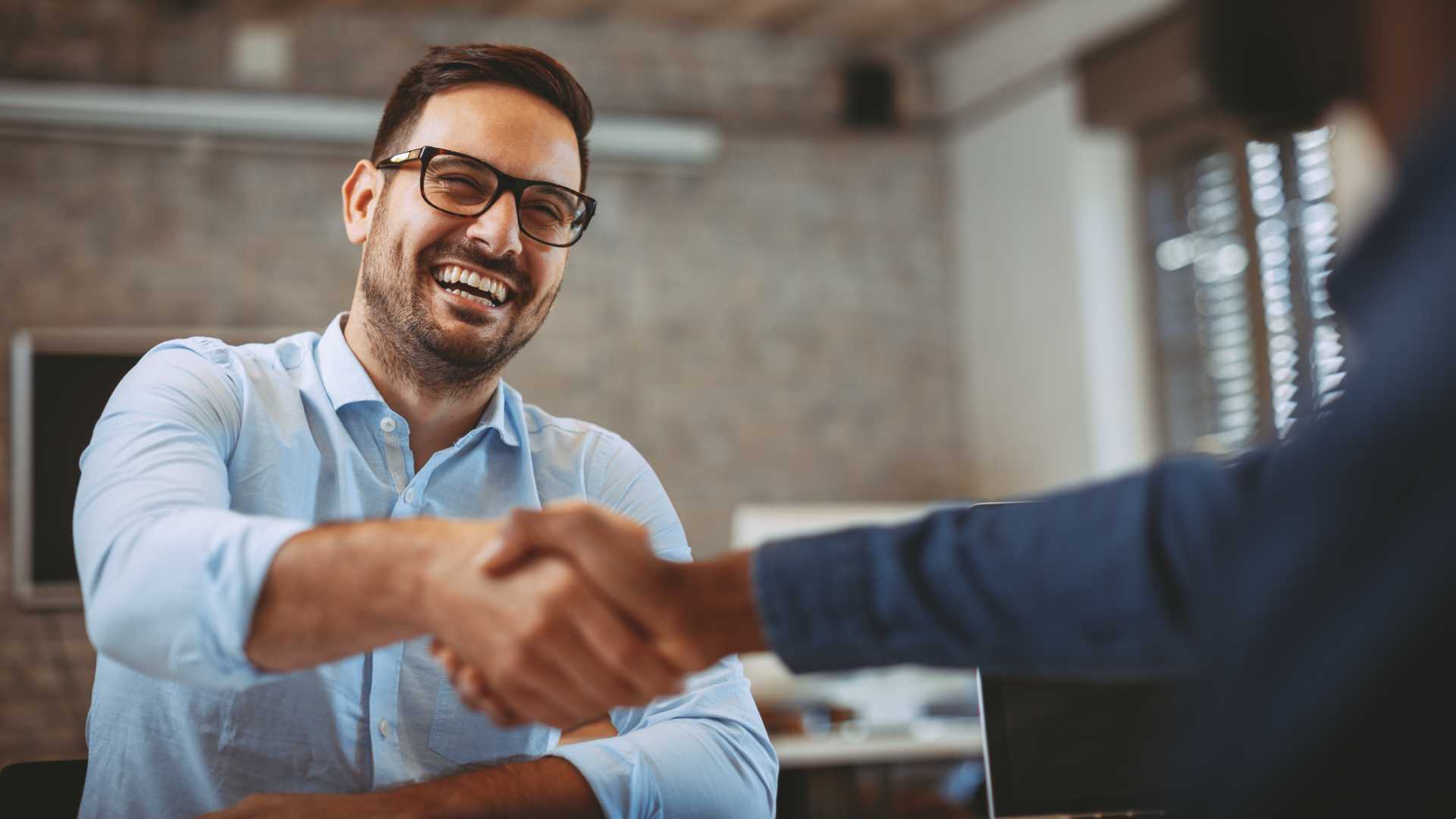 Man shaking hands with another individual.