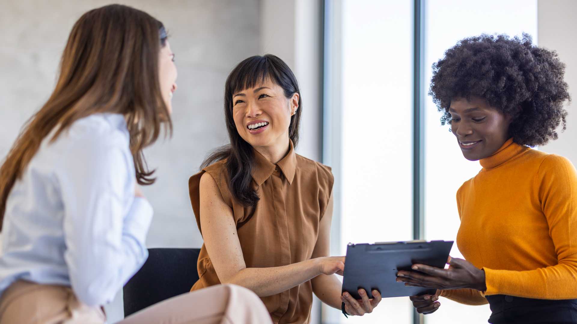 Woman coworkers discussing something.