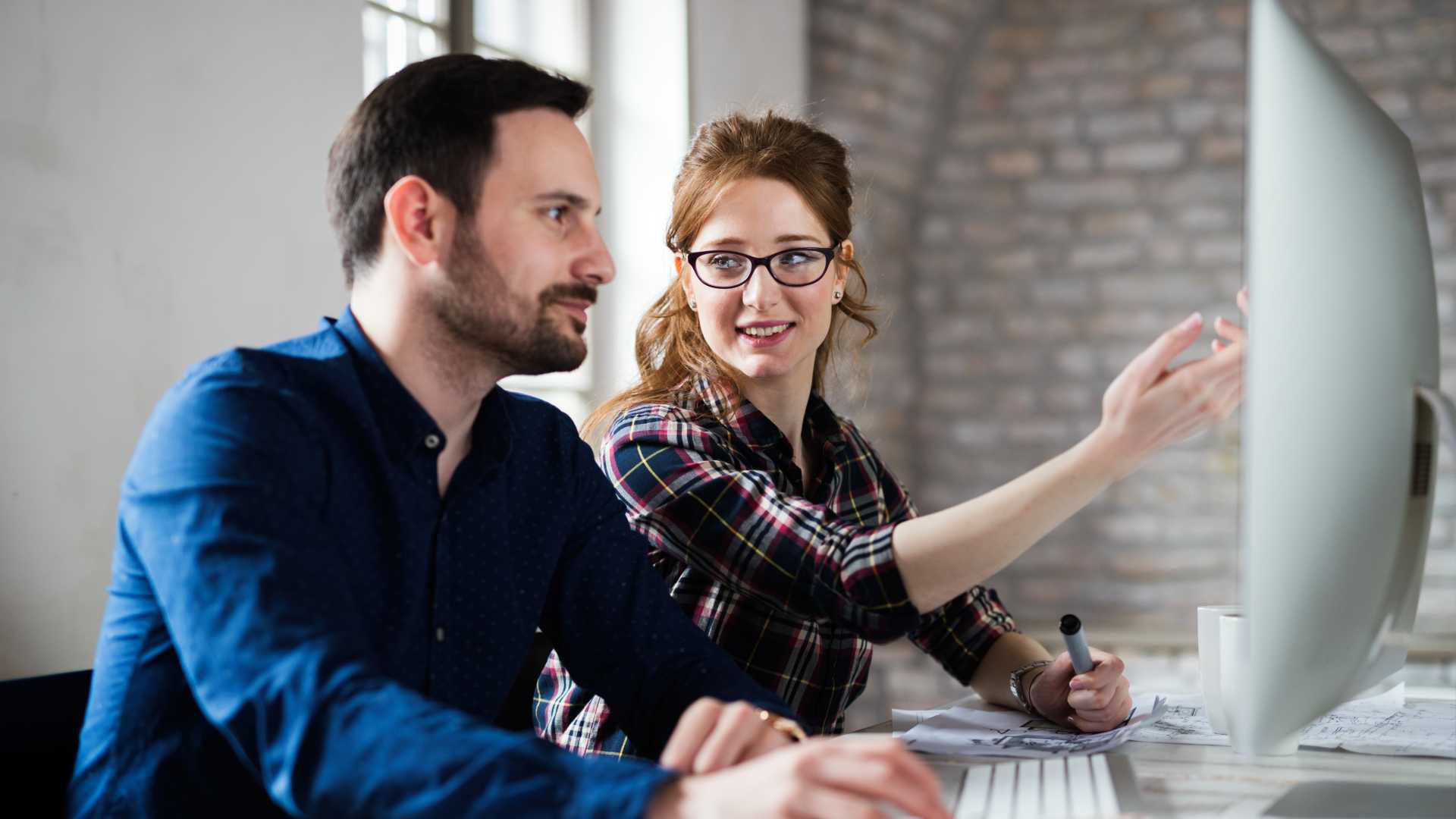 Man and woman looking over something on the computer.