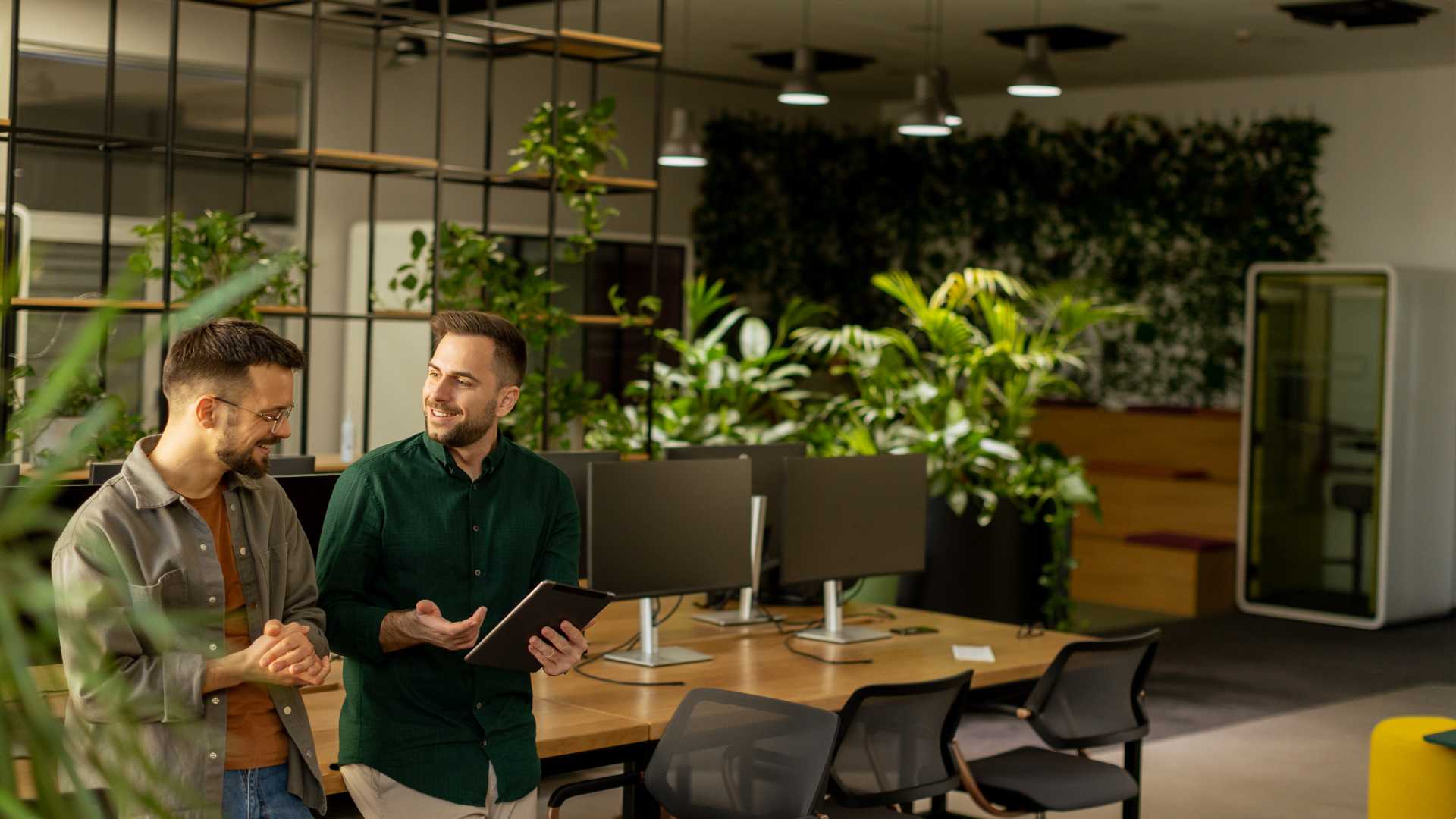 Two people working in a office with green space.