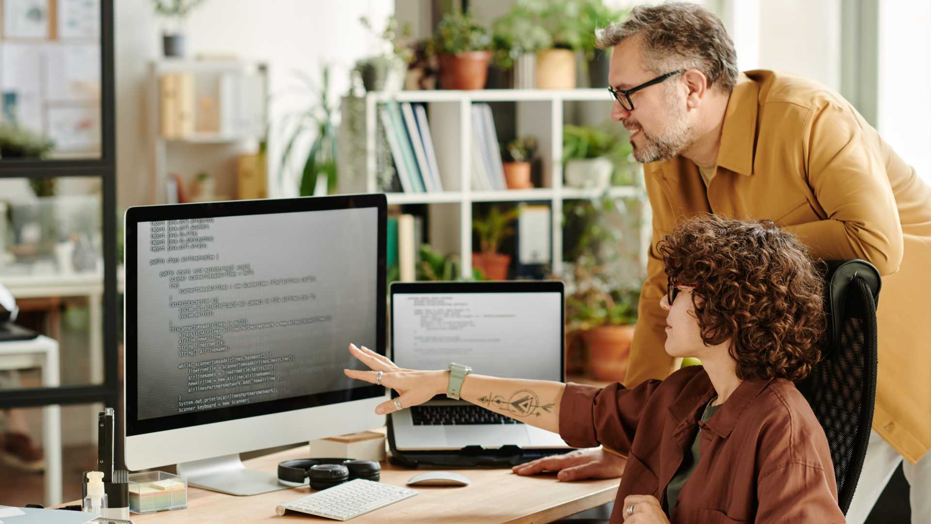 Man looking over coworker for a project.