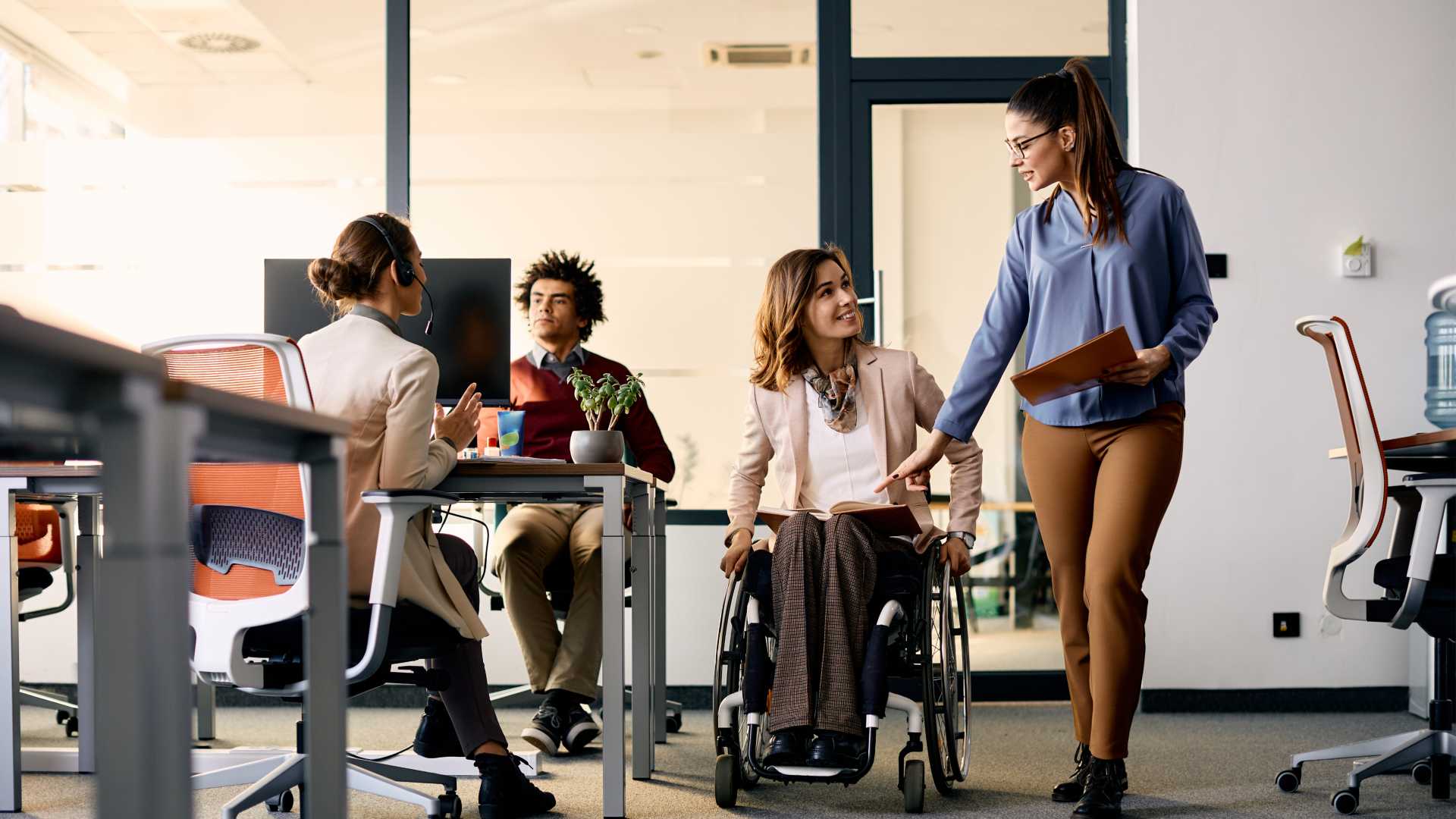 Woman in a wheerchair with boss discussinh brand deals.