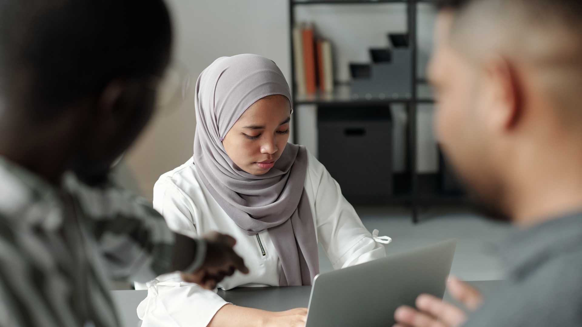 Woman using her laptop during a team meeting.