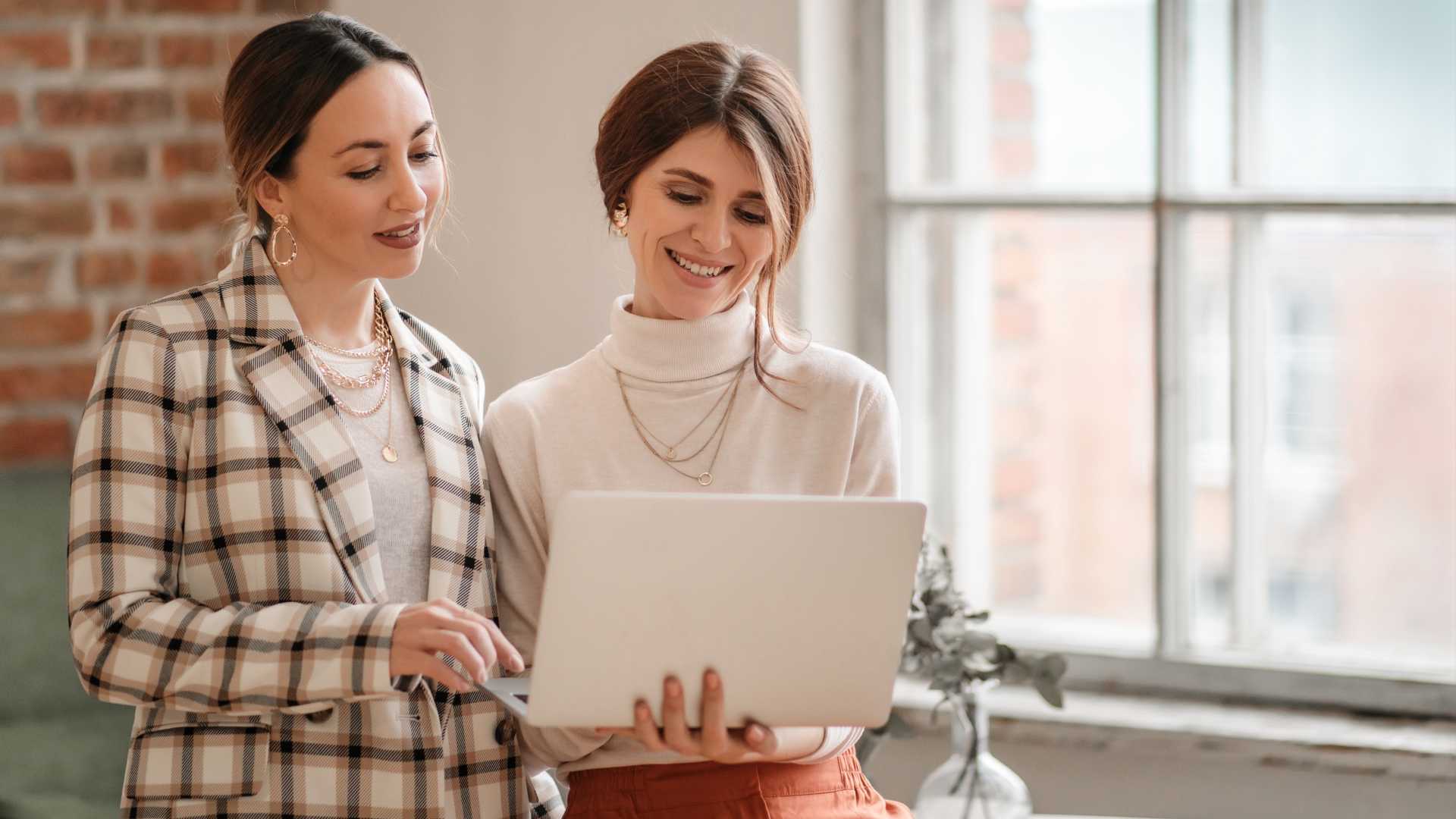 Two women looking a computer together.