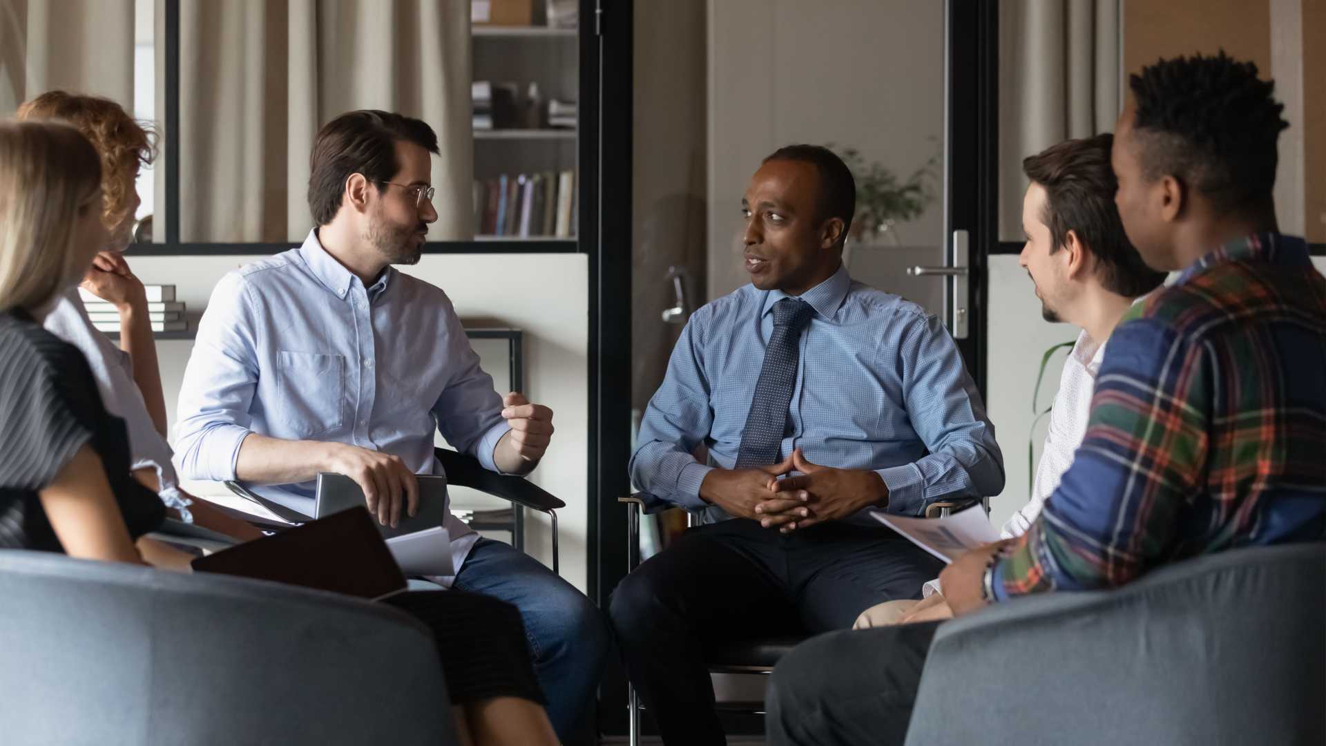 Multiple people in a diverse team meeting.