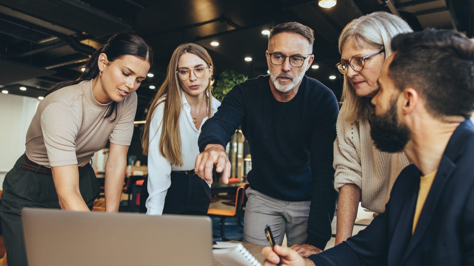 Diverse group of people looking at computer.
