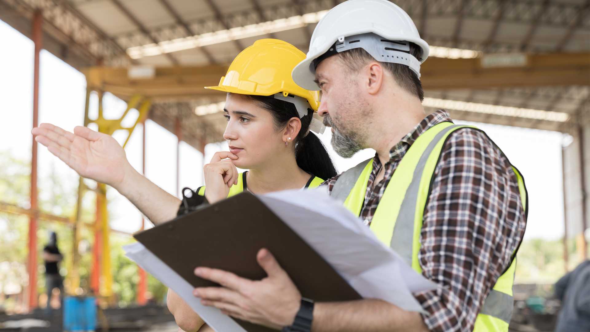 Female and male frontline worker discussing plans for construction.
