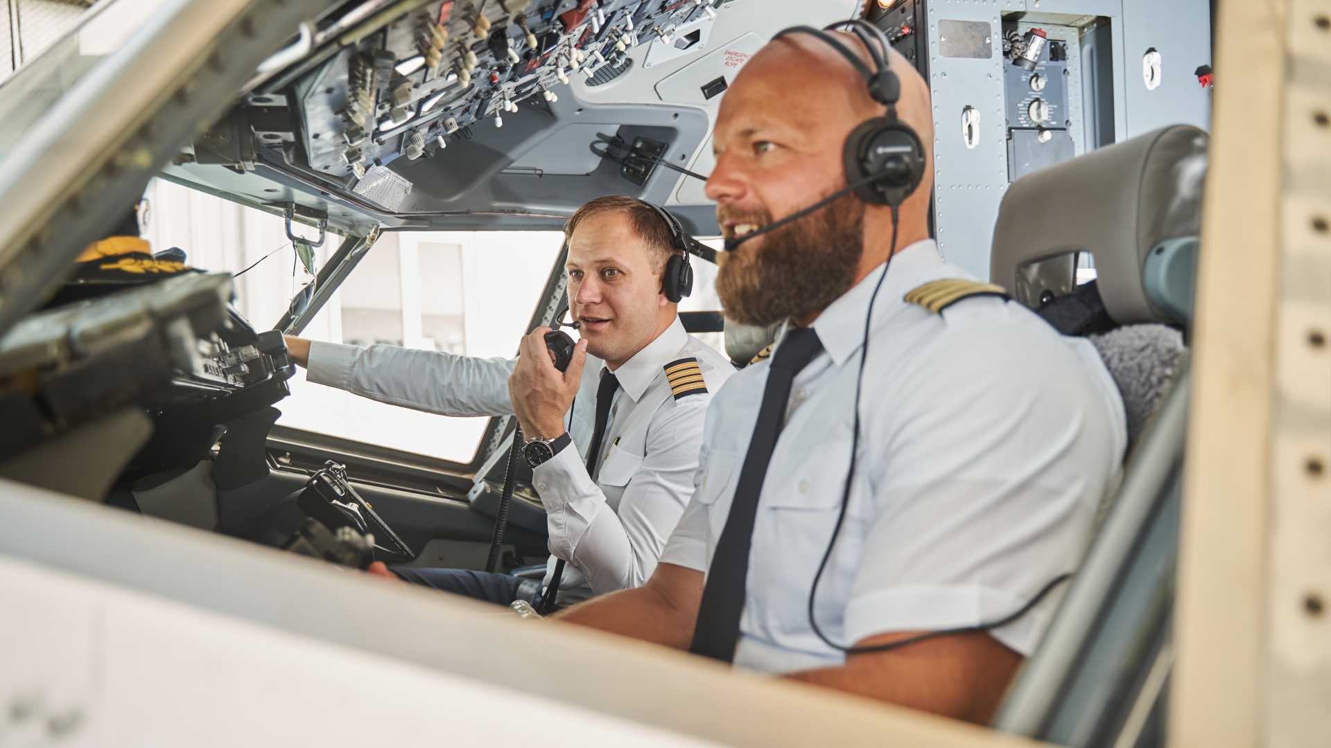 Pilots in the cockpit doing aviation work.