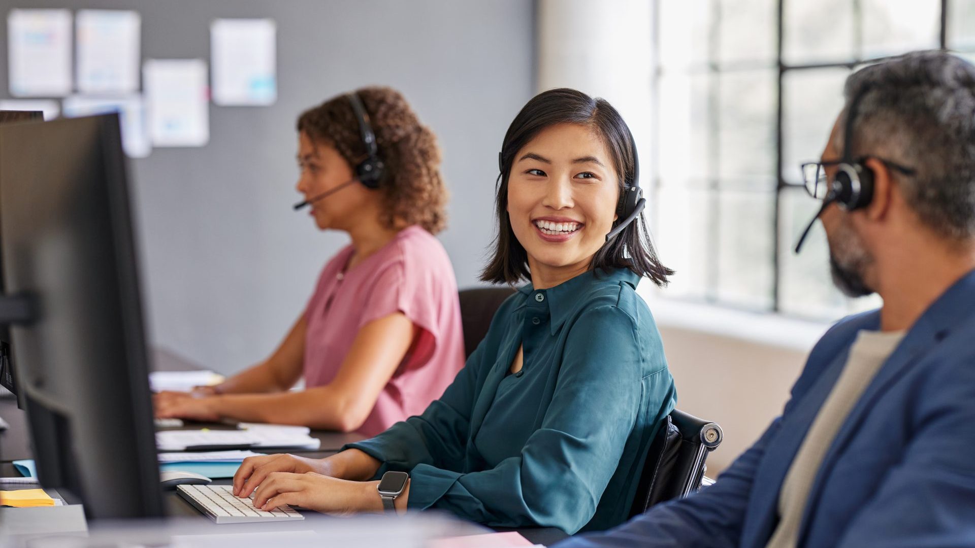 People working at a call center with headphones on.