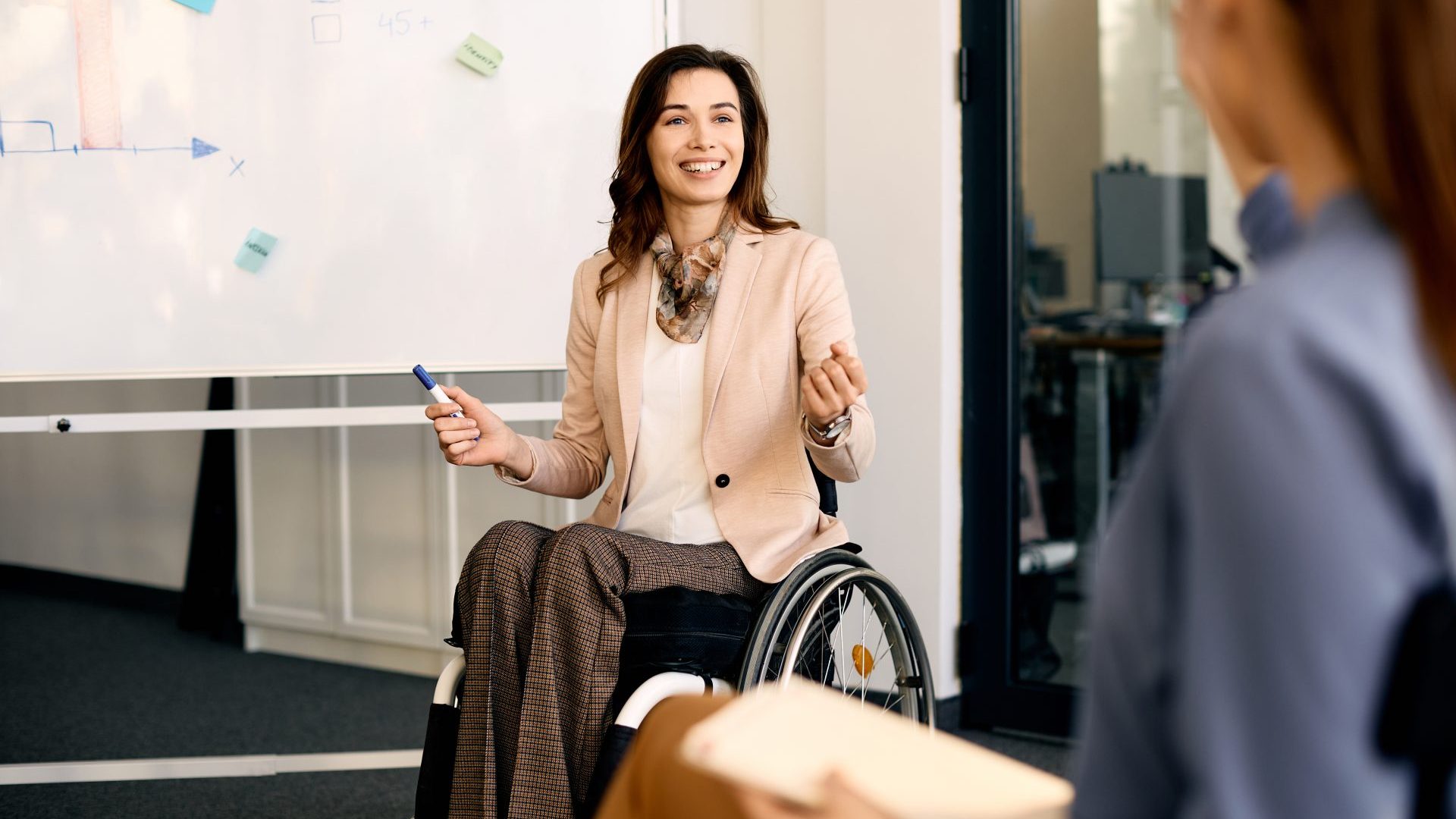 A woman in a wheelchair in team meeting.