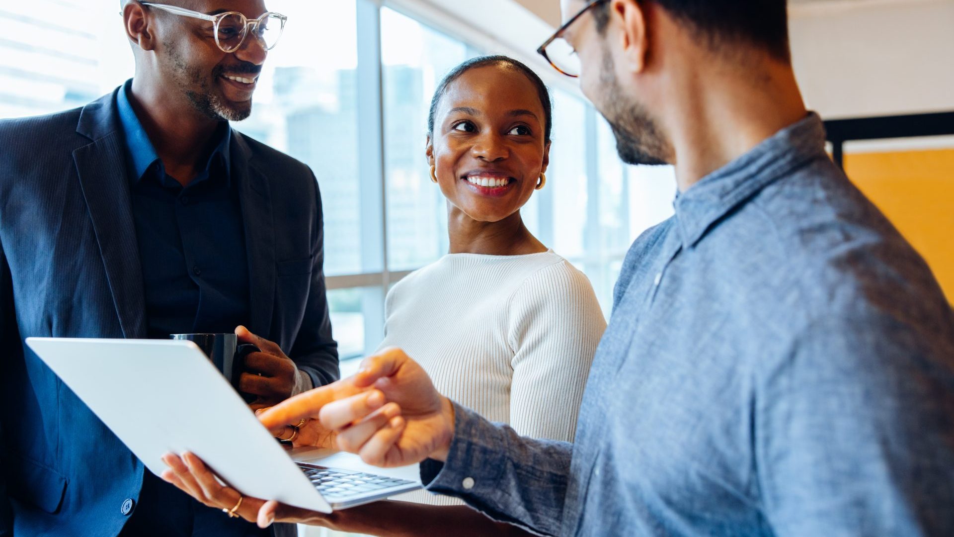 Three people in business attire in a professional setting in conversation