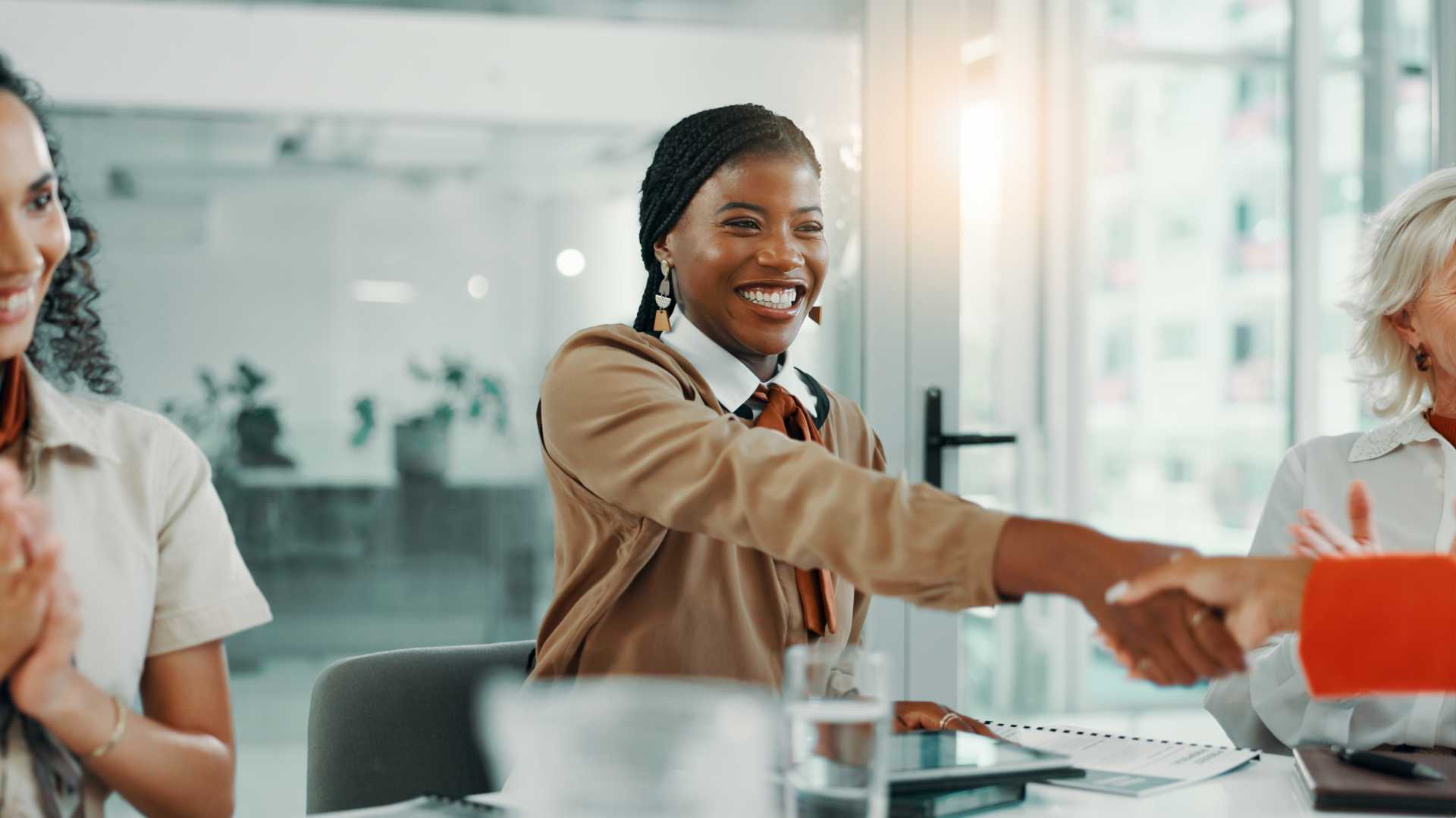 A businessperson shaking someone's hand in a conference room