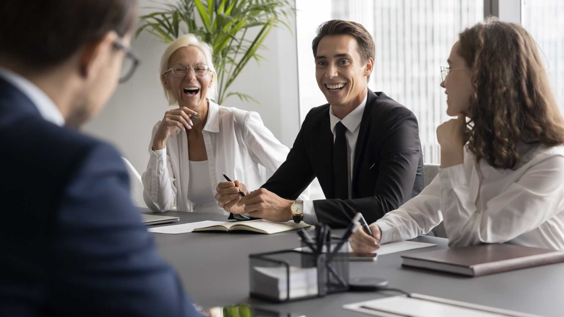employees from a multigenerational workforce collaborating in a workplace meeting, illustrating workplace culture, teamwork and organizational collaboration