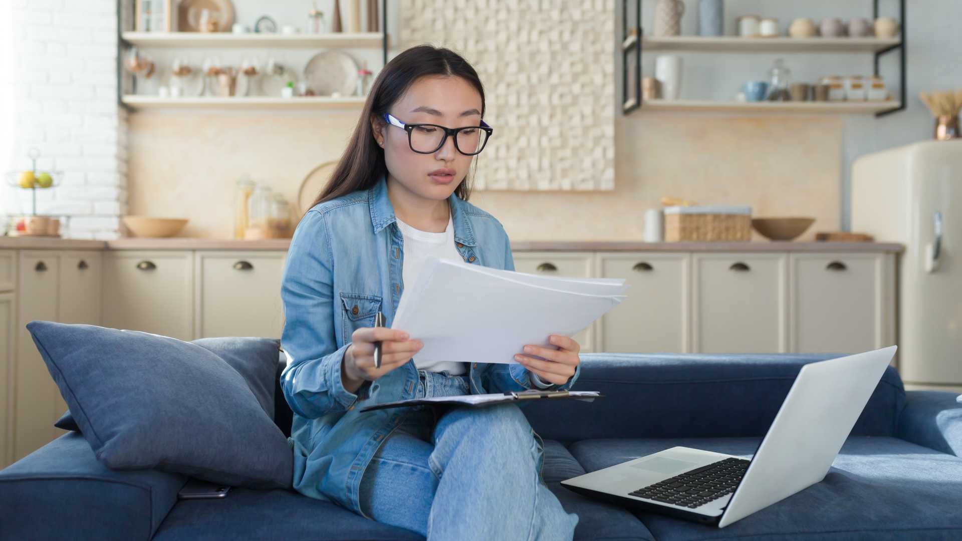 New employee reviews onboarding documents beside a laptop, illustrating executive onboarding, leadership transition support and preparation for a new leadership role.