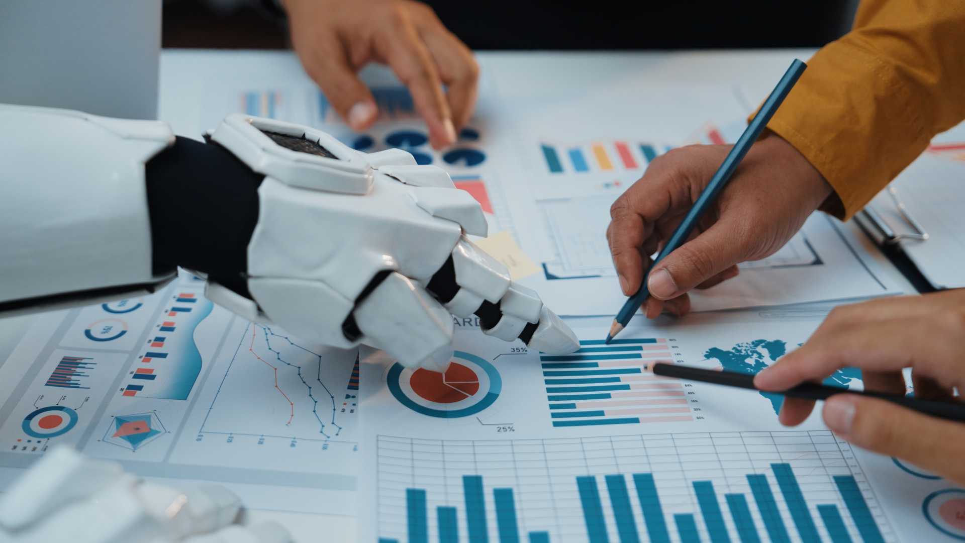 employees and an AI-powered robotic hand analyzing business data together, illustrating AI adoption, workplace collaboration and enterprise AI enablement
