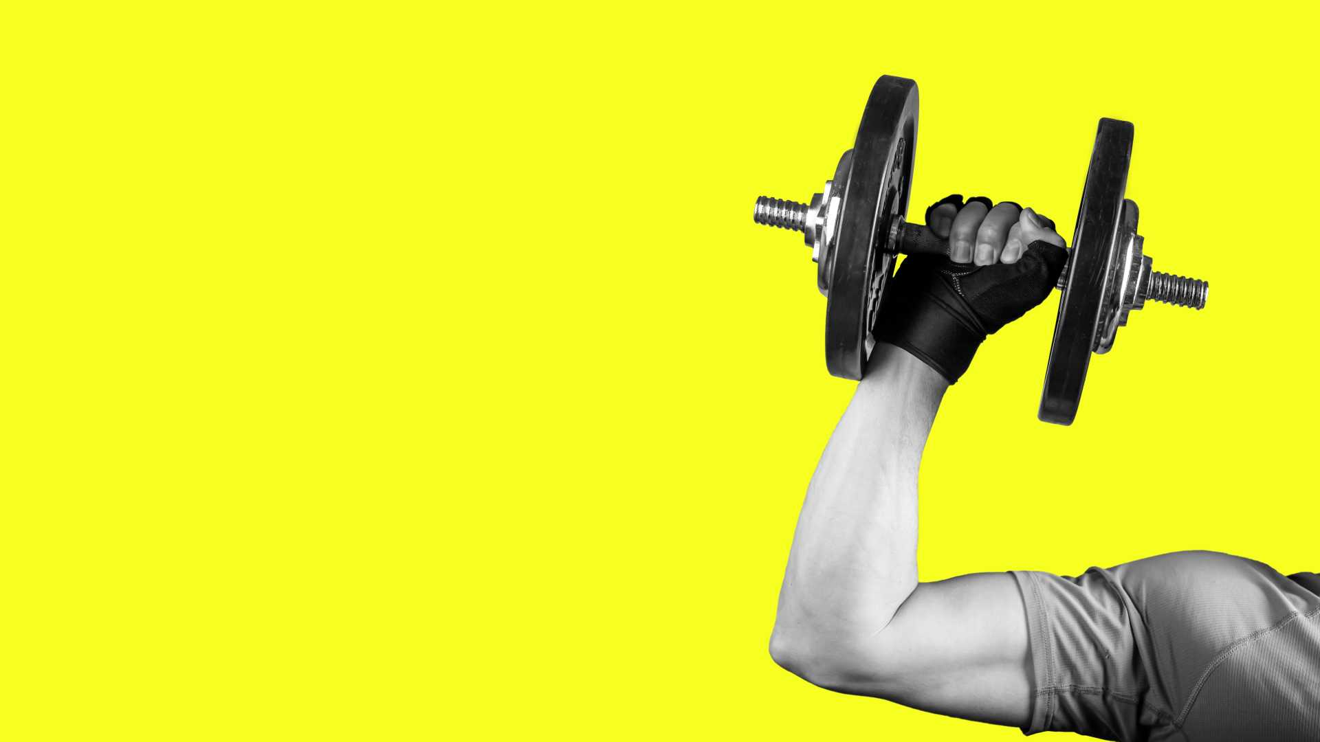 Person lifts a dumbbell against a bright yellow background, representing strength, progressive challenge and building capacity through manageable pressure.