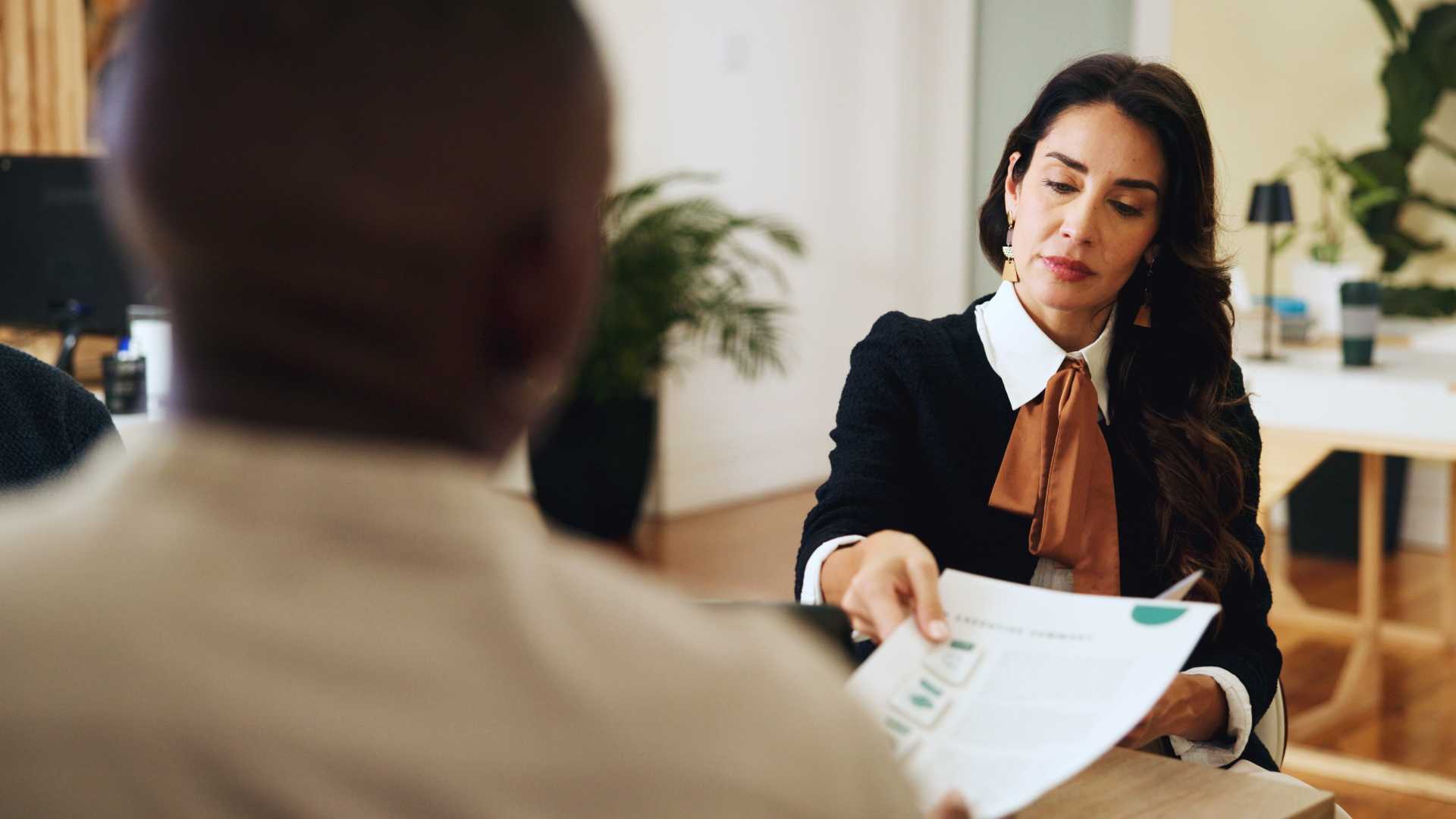 Manager reviewing a document with an employee during a private workplace conversation, representing manager preparedness and compliance training.