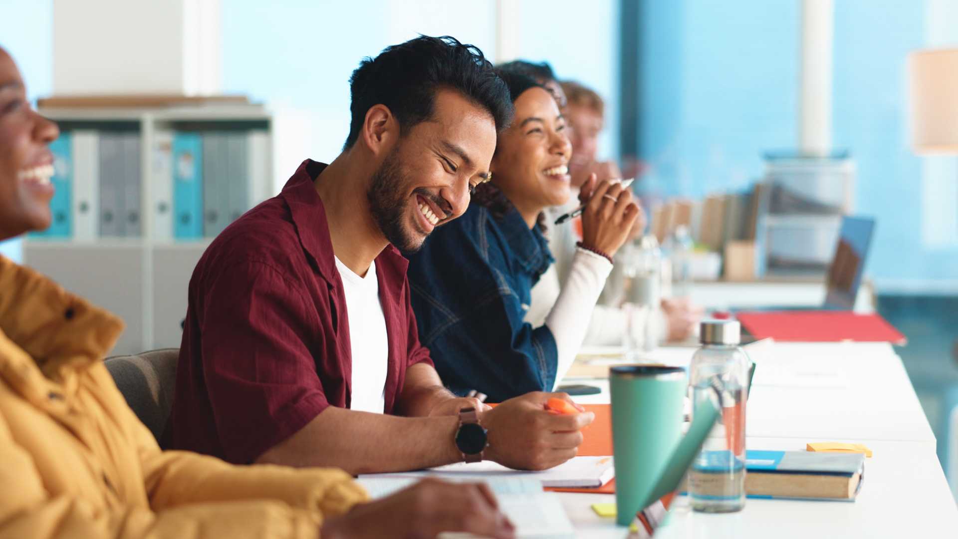 Employees participate in a professional development training session, taking notes and engaging in a group discussion.