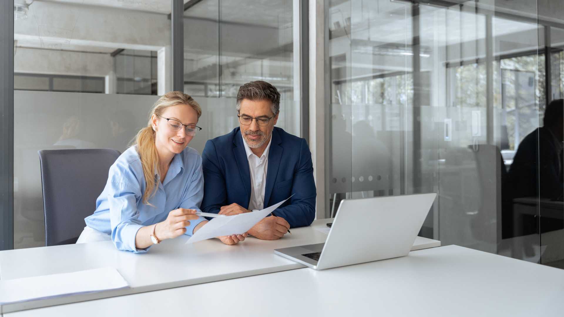 Manager and employee reviewing performance information together, illustrating how quality assurance, coaching and targeted training can improve conversation performance and employee effectiveness.