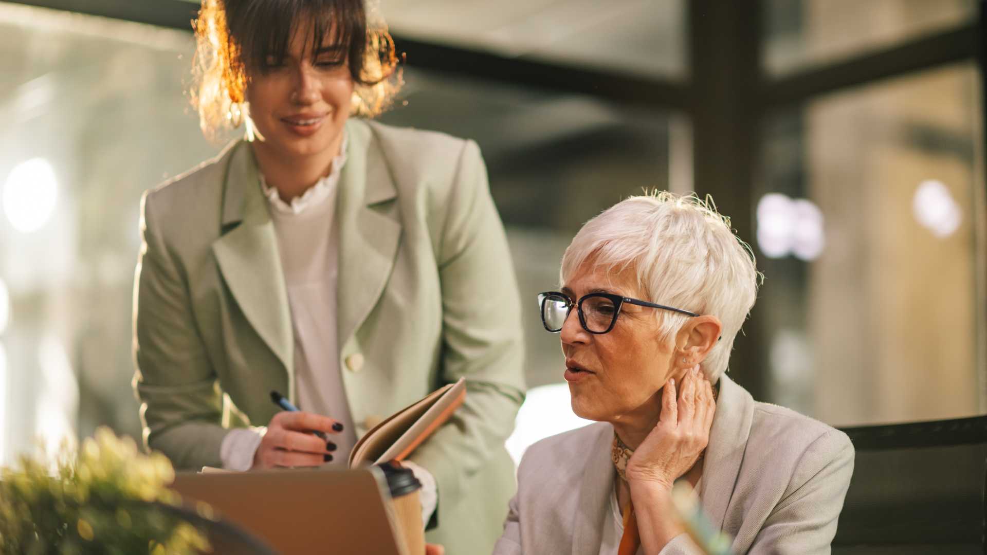Sales manager coaching a representative during a workplace discussion, illustrating how ongoing sales enablement, feedback and reinforcement can support lasting behavior change.