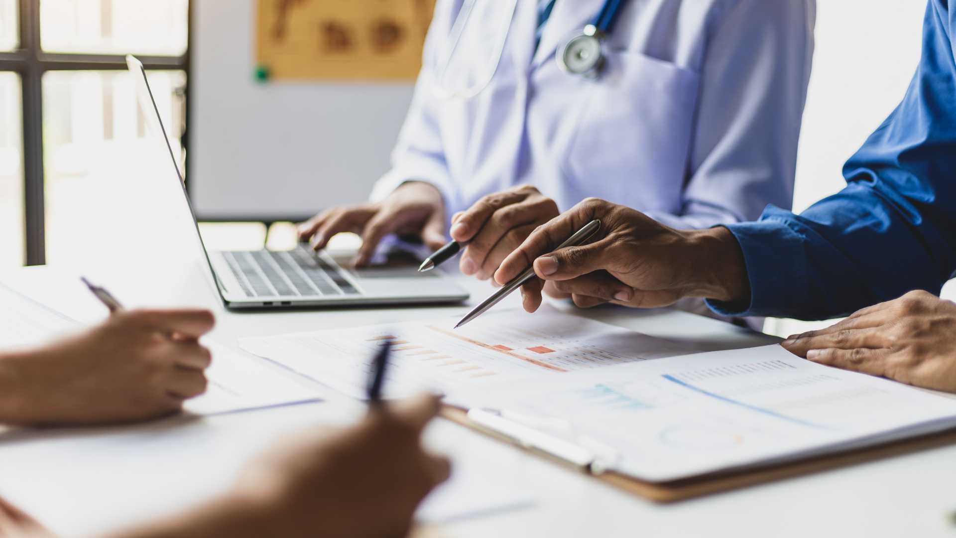 Employees reviewing workplace materials and performance data, illustrating how customized training can reflect real-world scenarios while maintaining consistent learning standards.