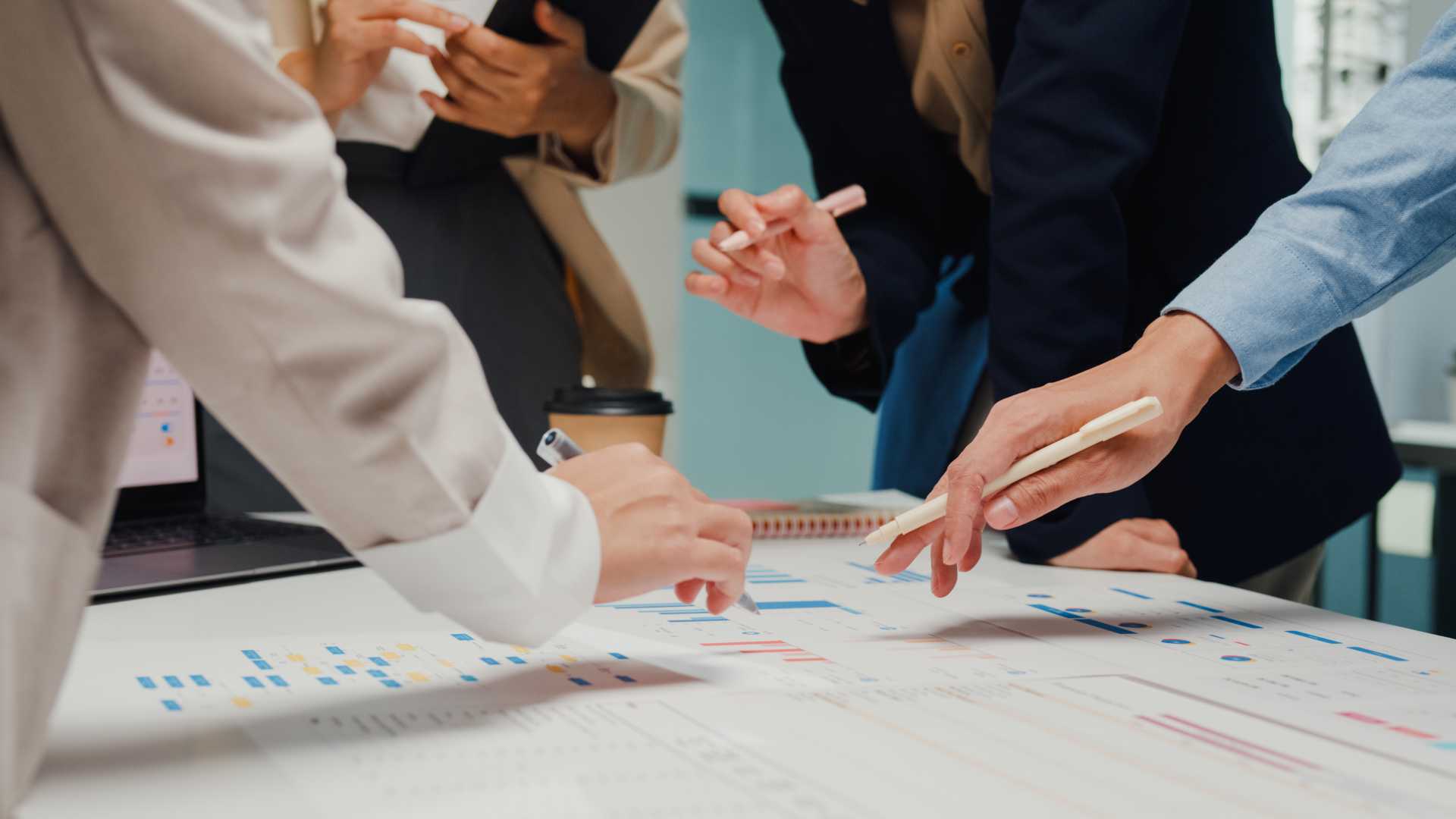 Employees reviewing charts and sharing ideas during a collaborative workshop, illustrating how shared learning builds team alignment, collective judgment and capability.