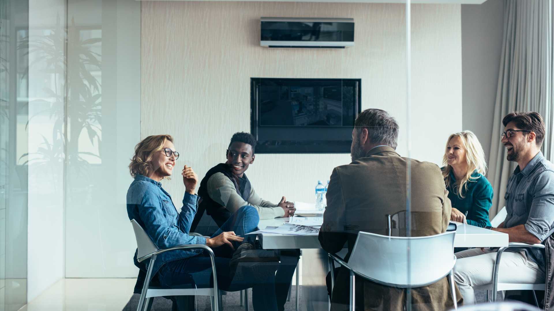 Leaders and employees discussing organizational change together, illustrating communication, collaboration and manager support during AI adoption and workforce transformation.