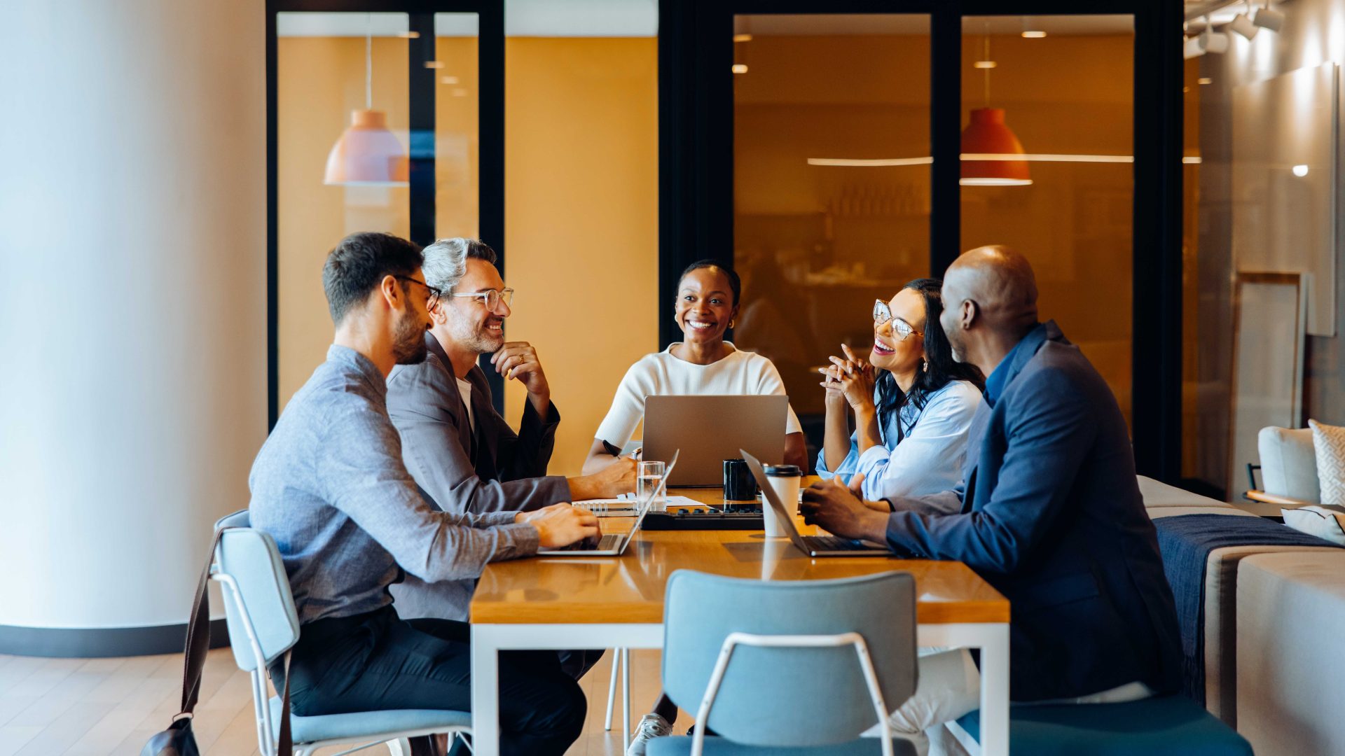 Professionals collaborating around a conference table, illustrating how L&D facilitation strengthens teamwork, human connection and organizational alignment in the age of AI.
