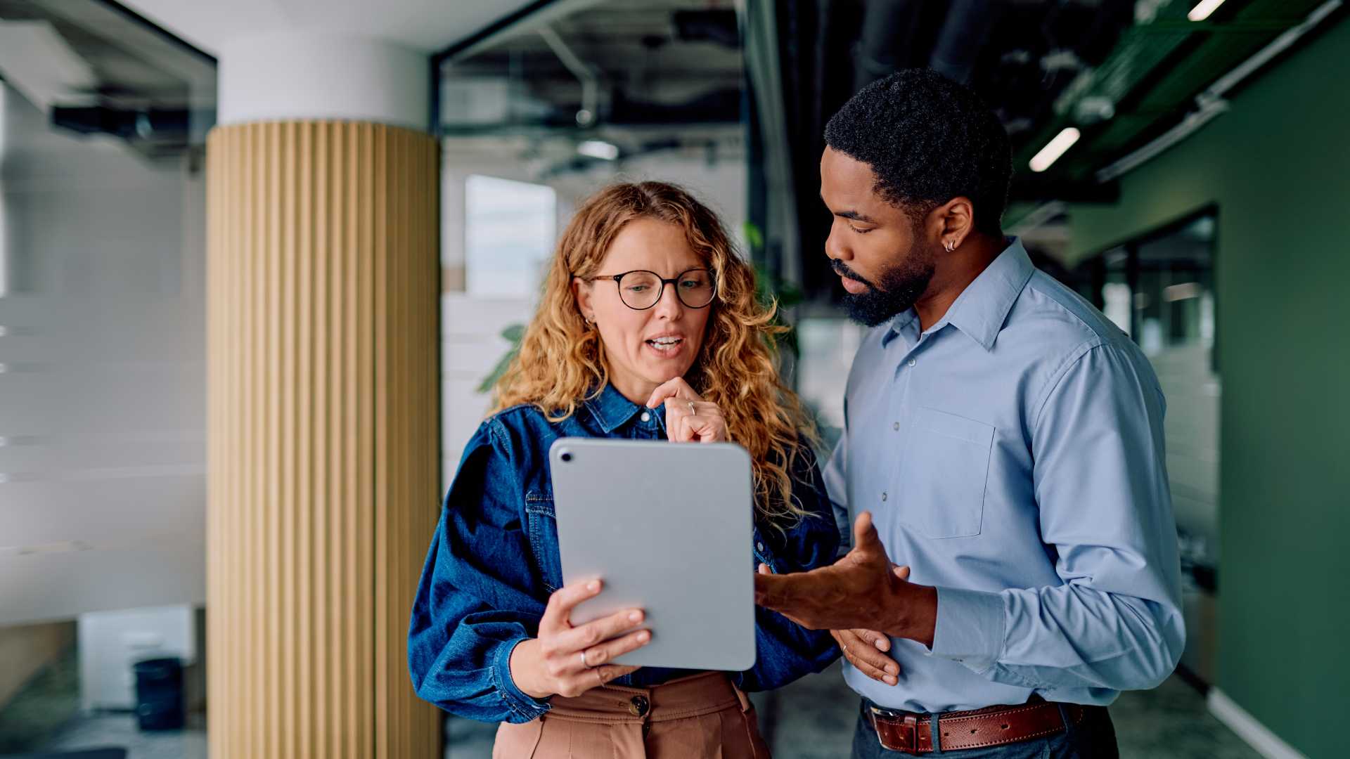 Manager and colleague reviewing workplace performance feedback, illustrating how coaching effectiveness can be measured through observable behavior changes while protecting confidentiality.