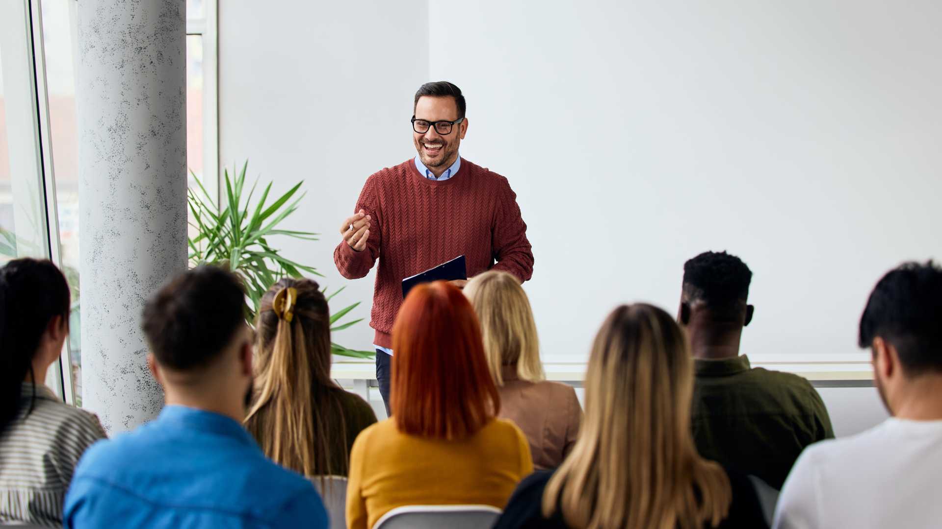 Leader speaking to a group of employees during a workshop, illustrating how persuasive communication, trust-building and dialogue strengthen leadership skills.