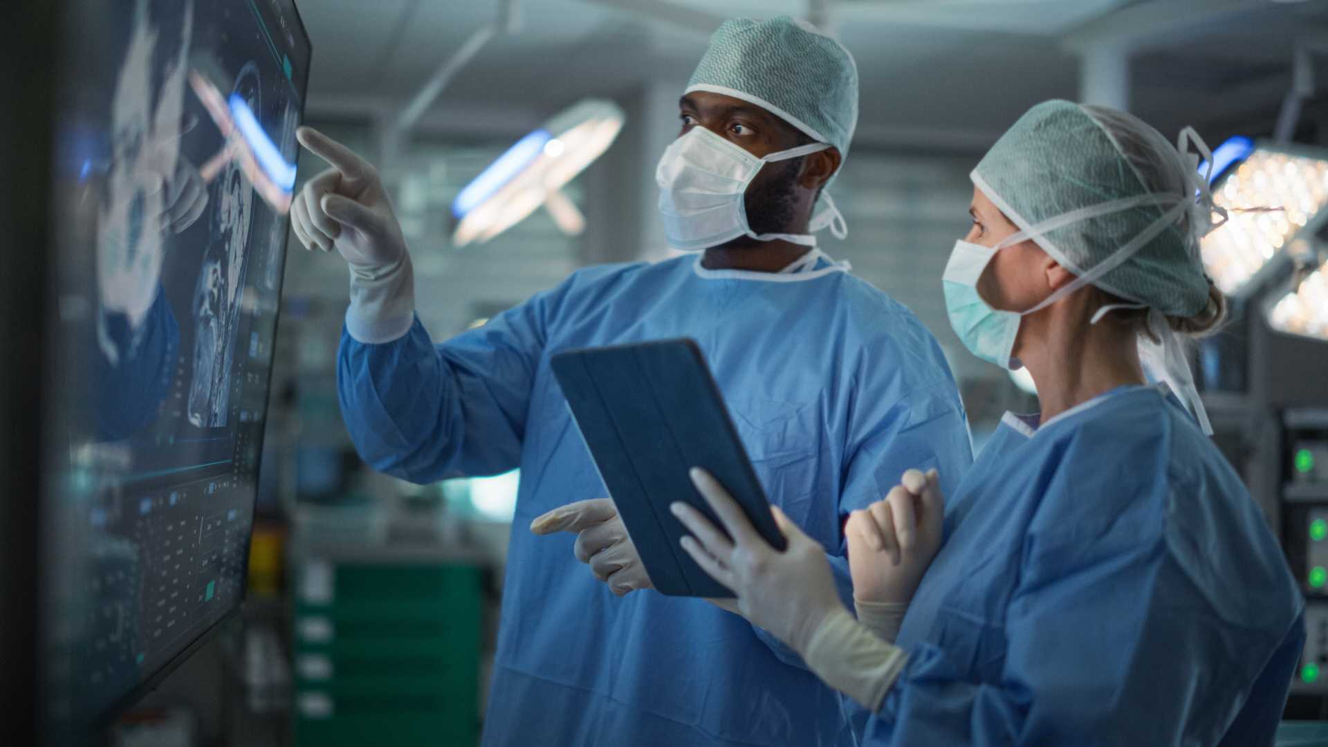 Medical professionals reviewing digital imaging and patient information in an operating room, illustrating collaborative decision-making, situational awareness and readiness under pressure.