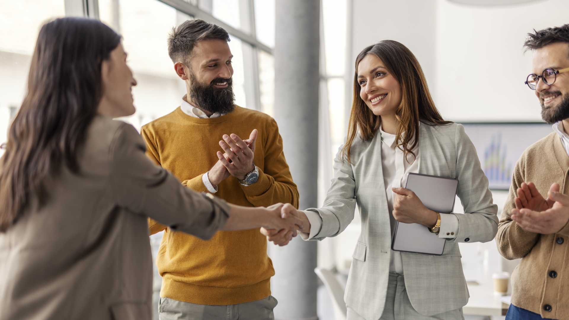 Business executives shaking hands during a meeting, representing mergers, acquisitions and strategic investments in the corporate training industry during Q3 2026.