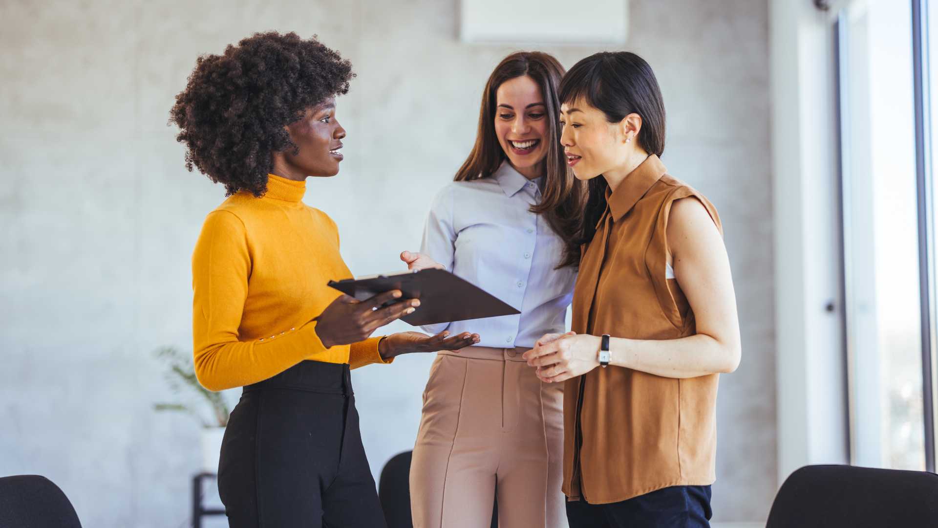 Business professionals discussing a project during a workplace meeting, illustrating communication skills, language proficiency and the application of corporate language training.