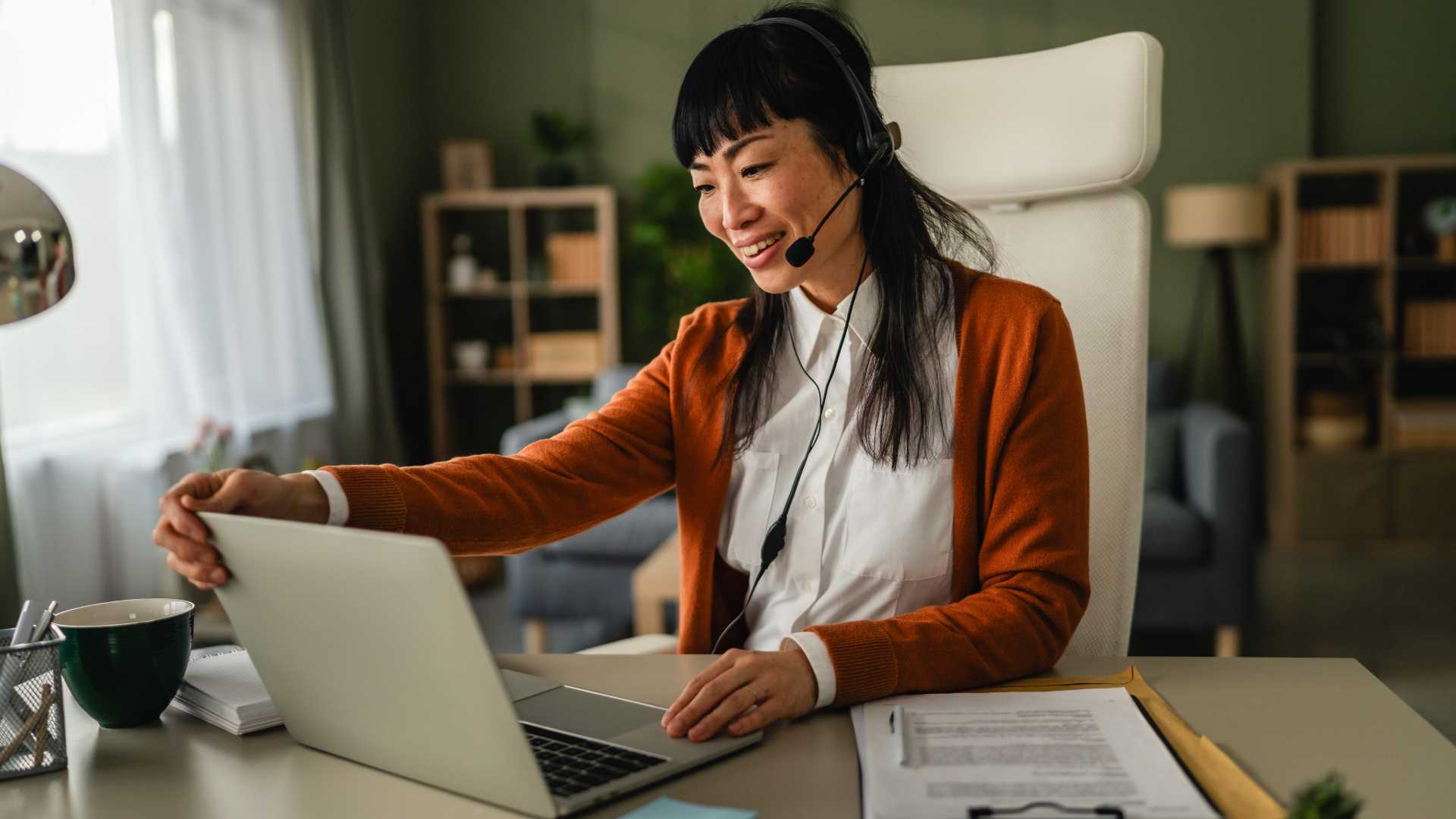 Professional wearing a headset and working on a laptop, illustrating interactive workplace training, scenario-based learning and decision-making practice.