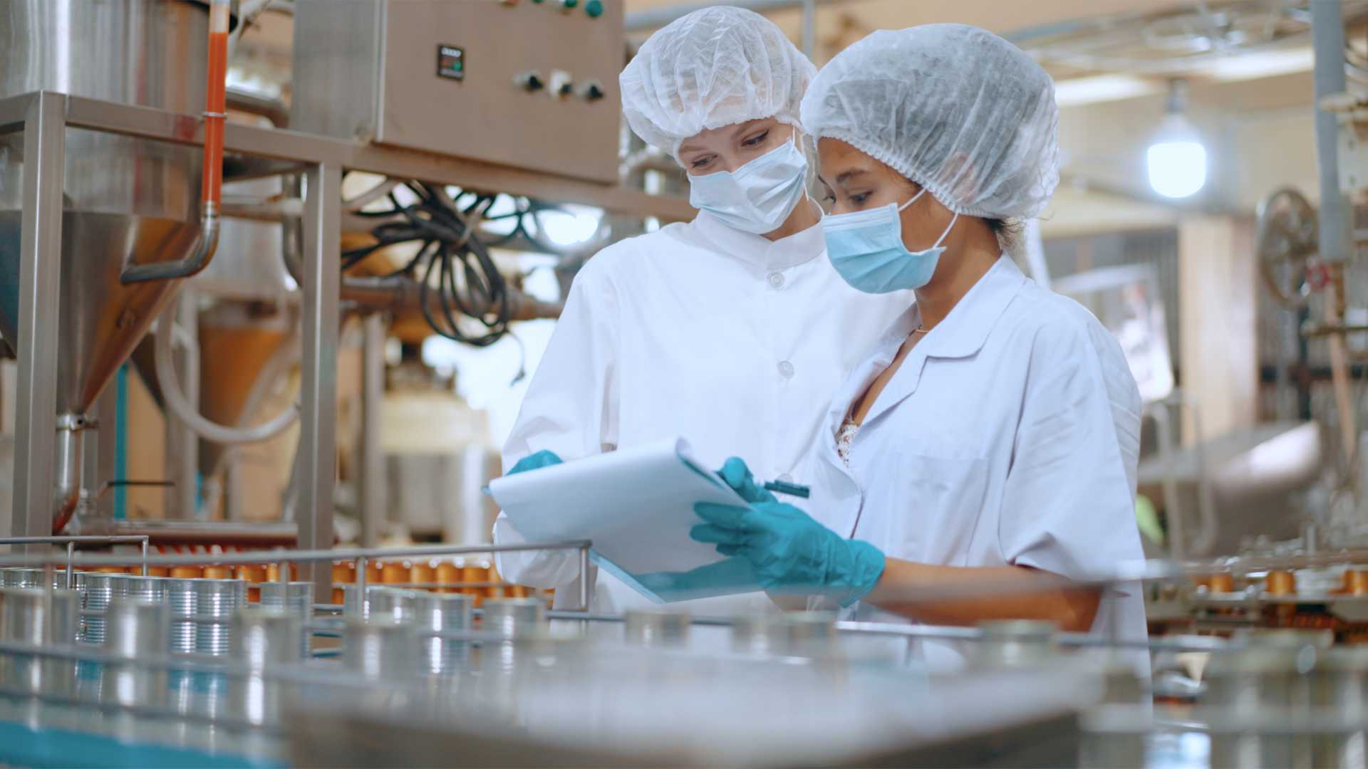 Food manufacturing employees following safety procedures on a production line, illustrating the importance of effective food safety training, workplace compliance and practical skills development.