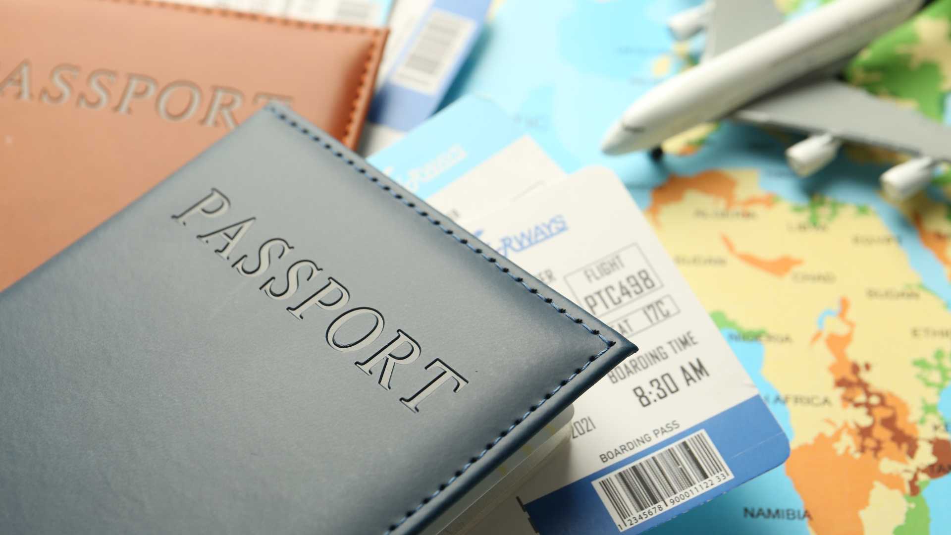 Passports, boarding passes and a model airplane resting on a world map, illustrating international travel and the development of cultural agility in global leadership.